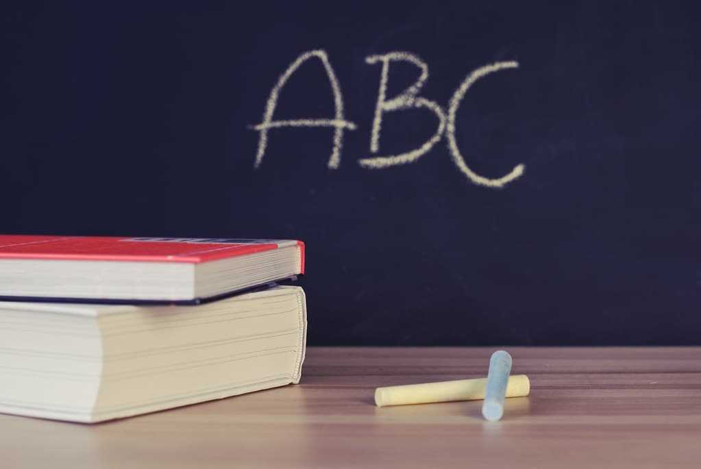 チョークで書かれたABCの文字と教材 — スペイン語のアルファベットとスペル通りの発音ルールをイメージした一枚