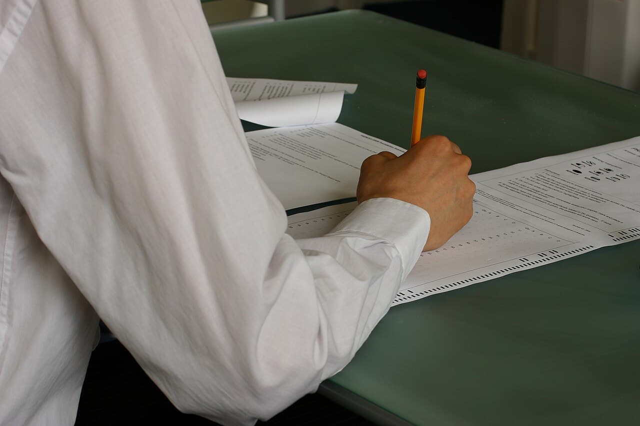 教室での筆記試験の様子。HSK4級の作文セクションのような、時間内に手を動かして書き切る試験本番の空気感。