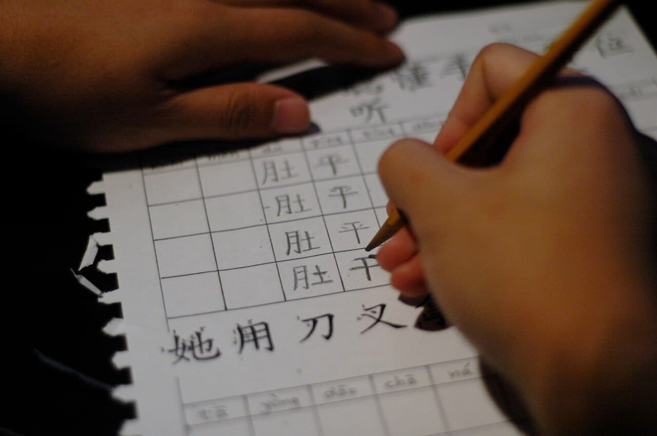 中国語の宿題ノート。ピンインと漢字を書き込みながら発音と文字を結びつけて覚える学習風景。