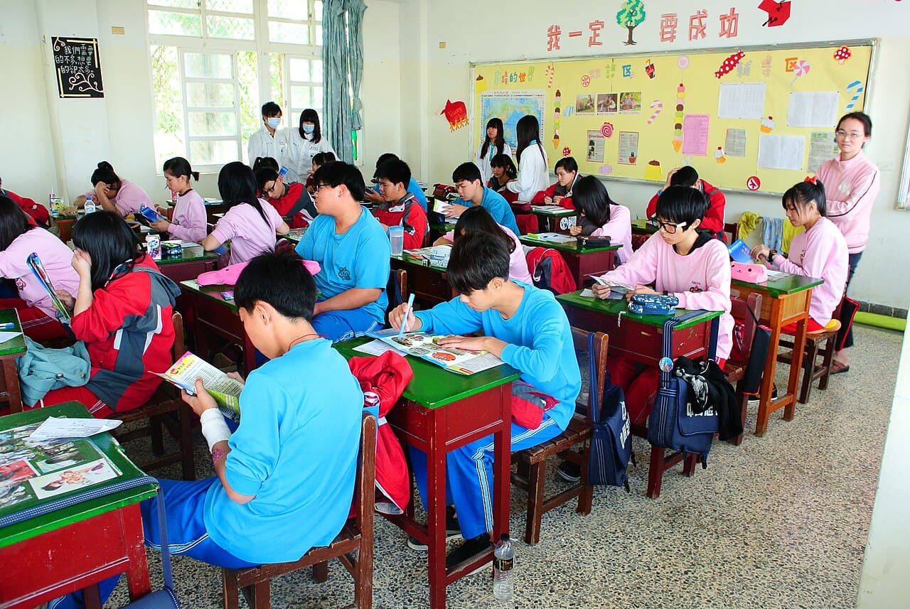 中国語圏の教室風景。HSK3級が目指す「生活の中の中国語がだいたい分かる」レベル感を、日常の教室の空気感で表すカット。